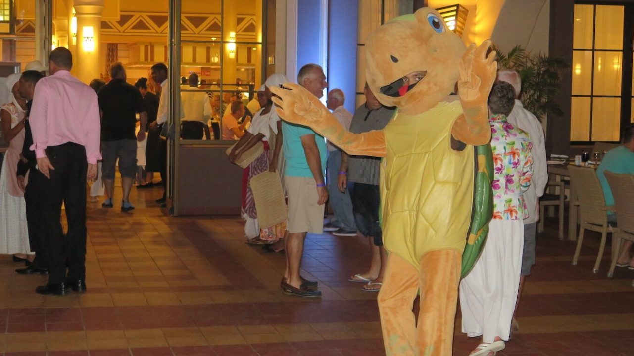 Man is sea turtle costume outside of a restaurant.