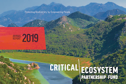 The cover of the annual report, featuring forested mountains behind a deep blue river.
