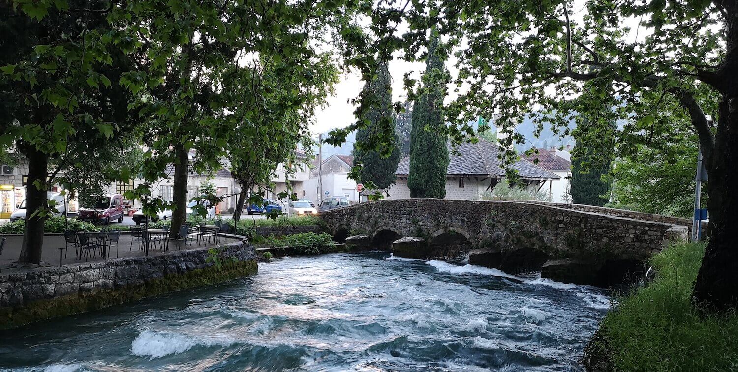 Río urbano con puente peatonal.