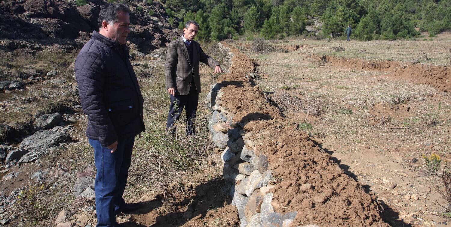 Dos hombres en la presa de piedra.