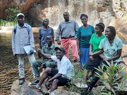 Communautés locales et parties prenantes devant une cascade dans la zone clé pour la biodiversité de Chimanimani