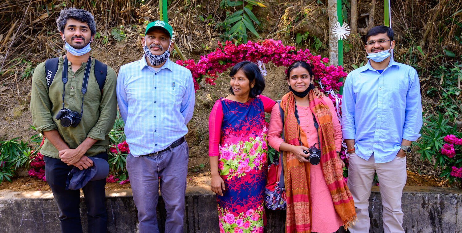 3 men and 2 women standing outside, smiling.