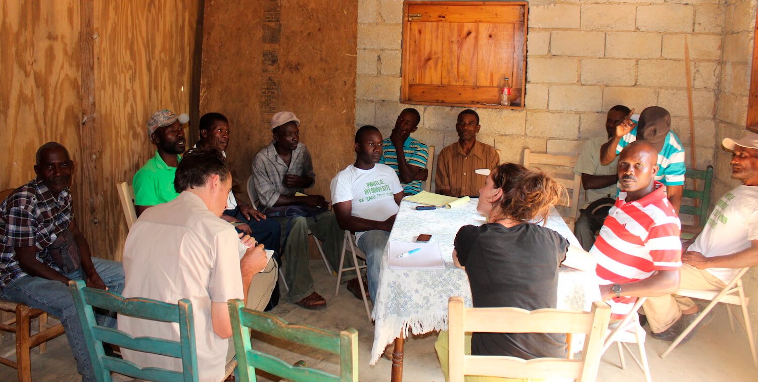 About a dozen people sitting around a table.