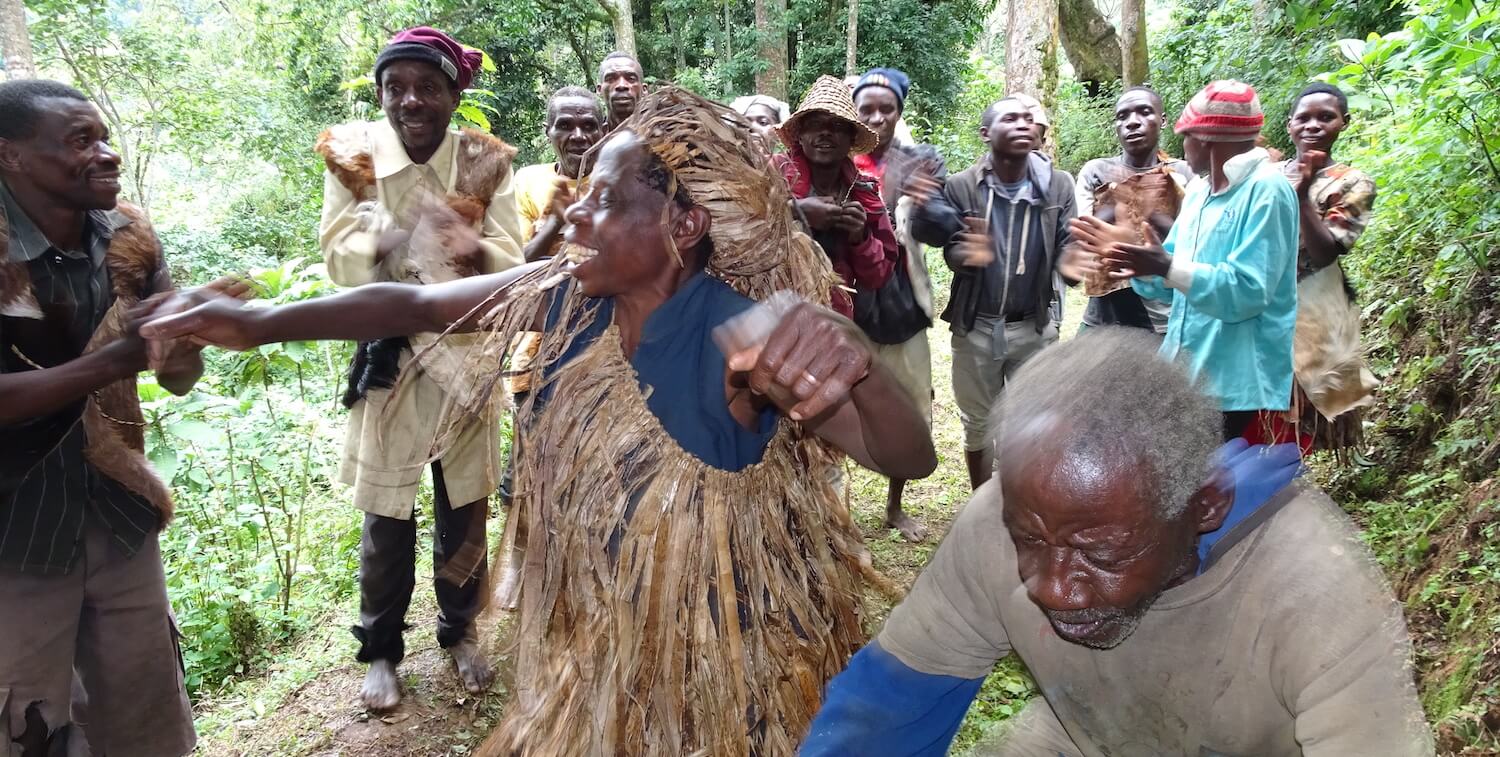 Group of people dancing on forest trail.