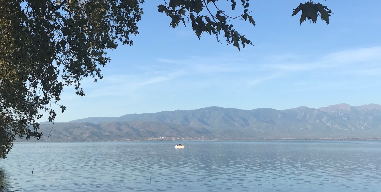 Lake vista, un bateau au loin et montagnes en arrière-plan