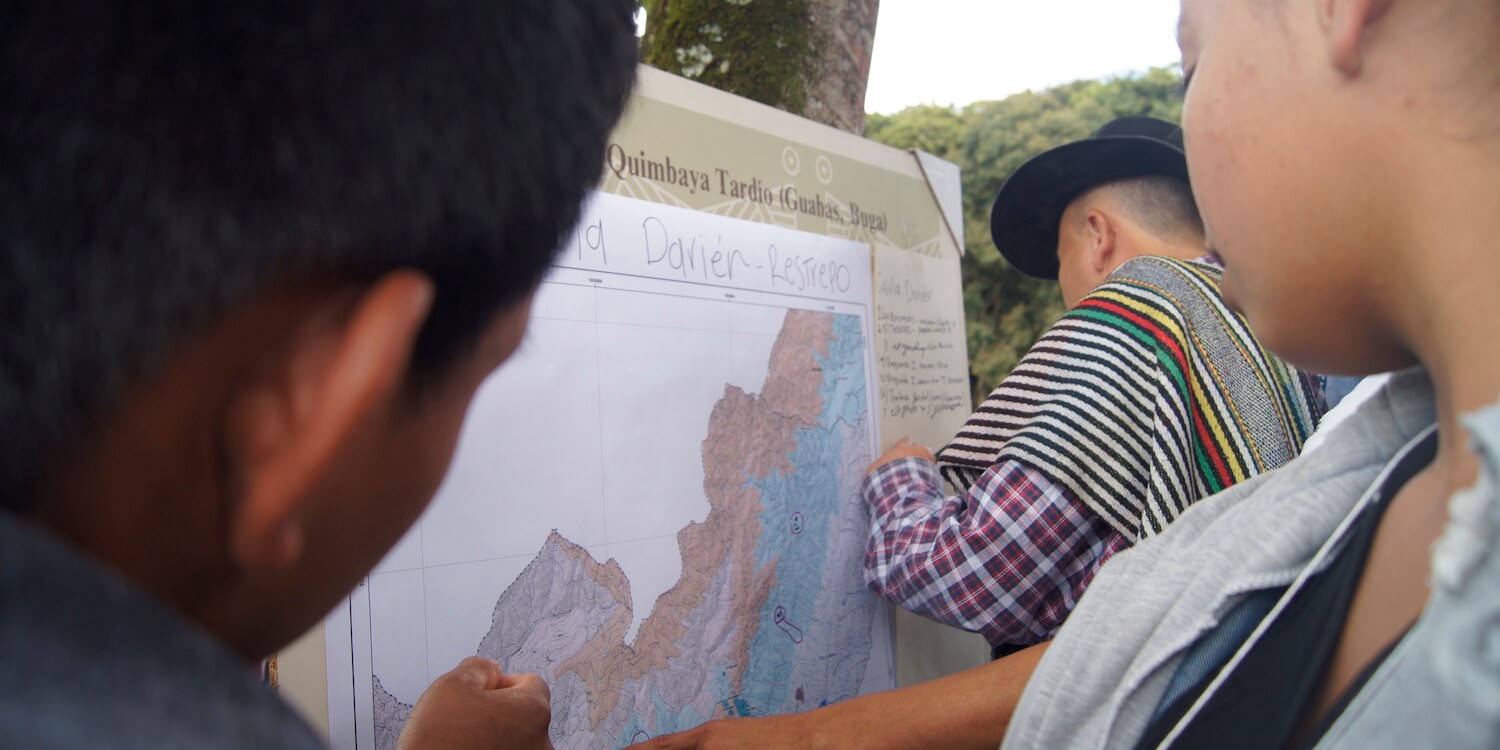 A few people looking at map on poster board.