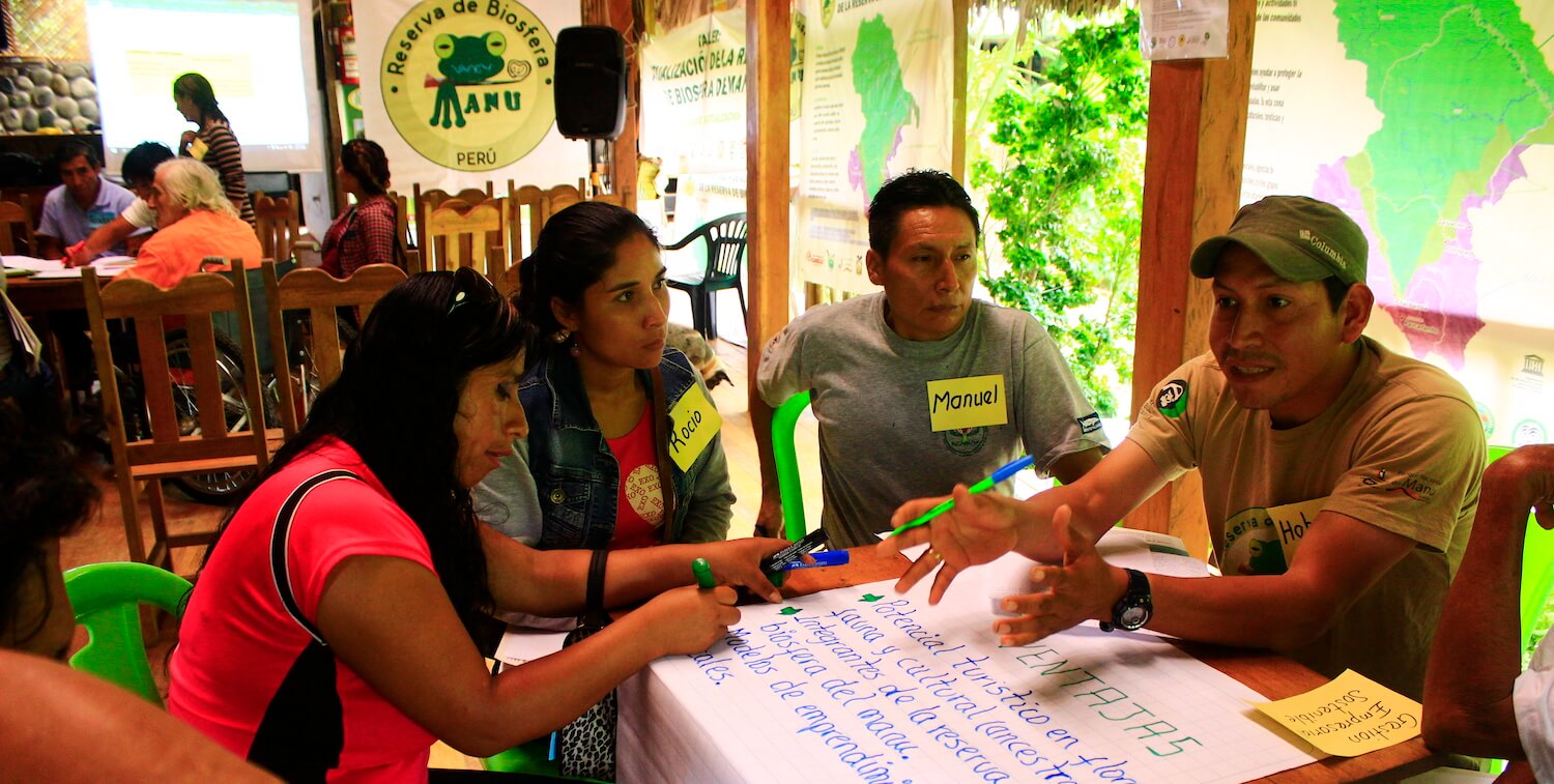 Group of four people at table in the middle of a discussion.