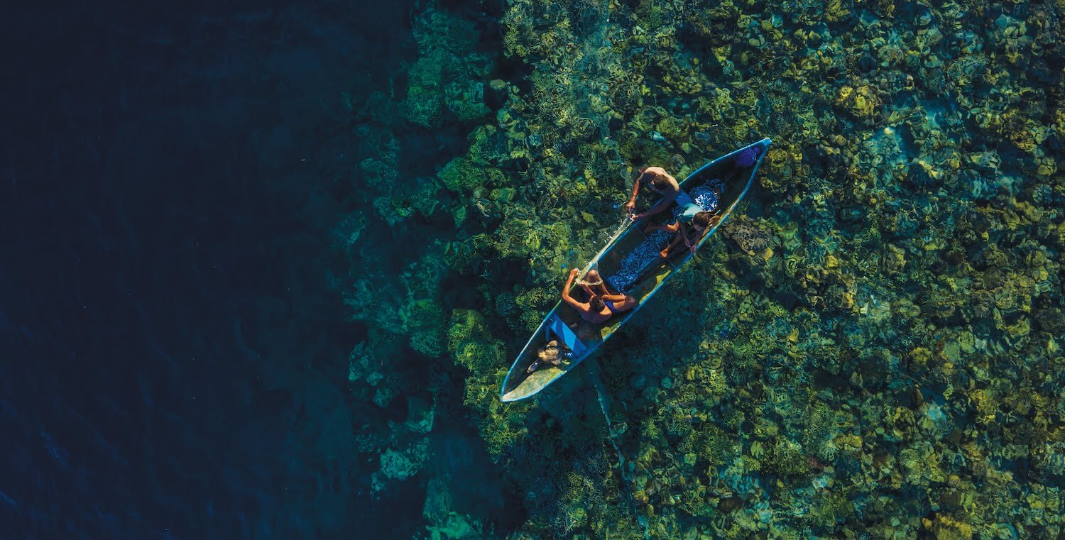 Aerial view of fisherfolk on water in canoe.