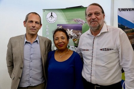 Two men, one woman, standing together, smiling at camera.