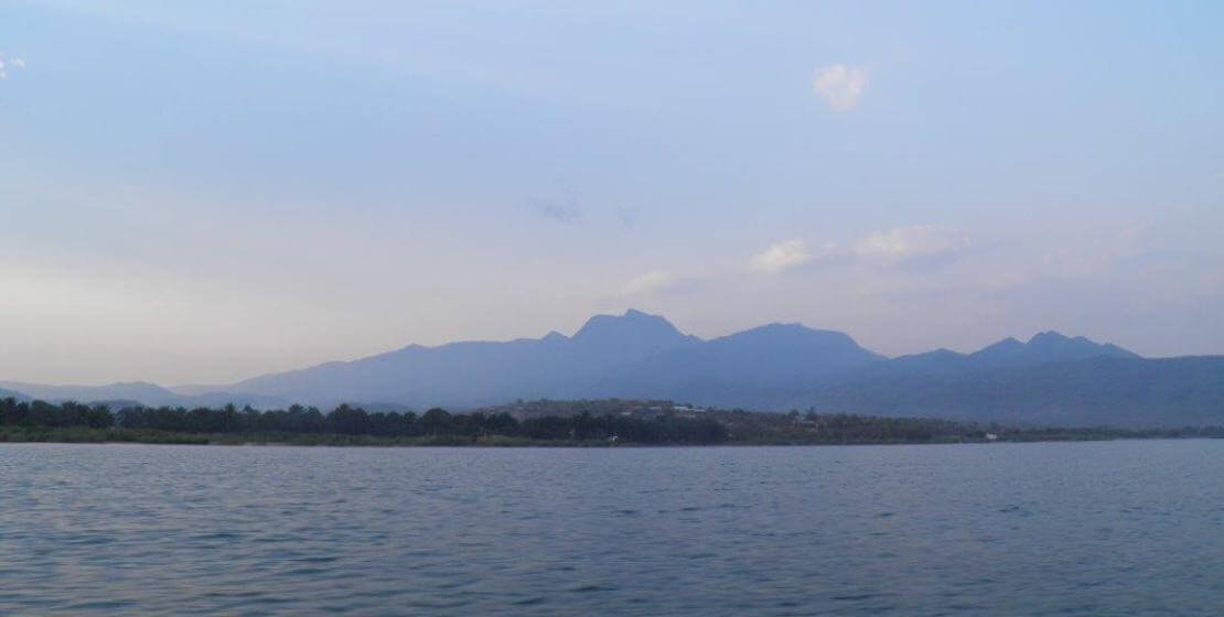 Water in foreground, mountains in background.
