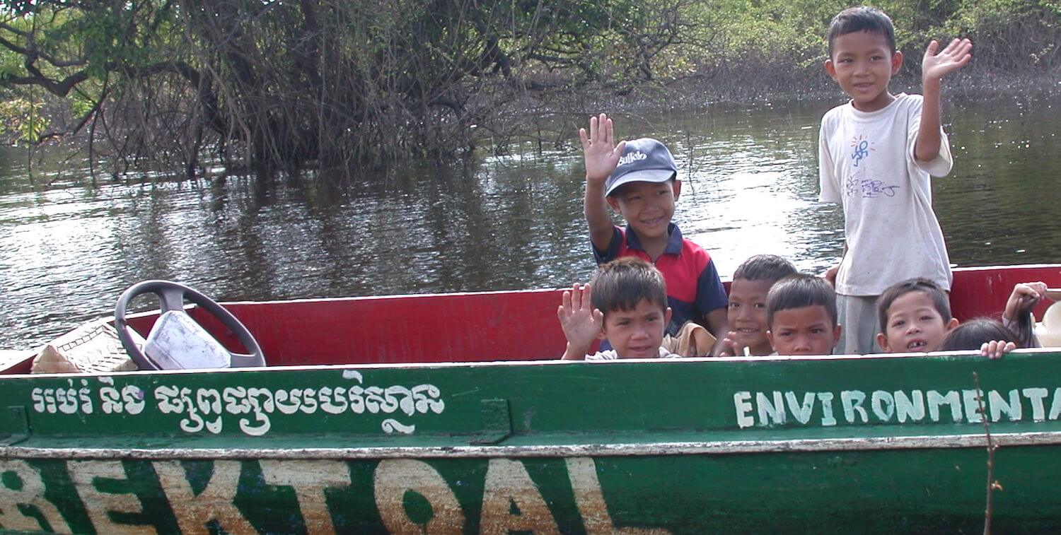 Children waving from small boat.