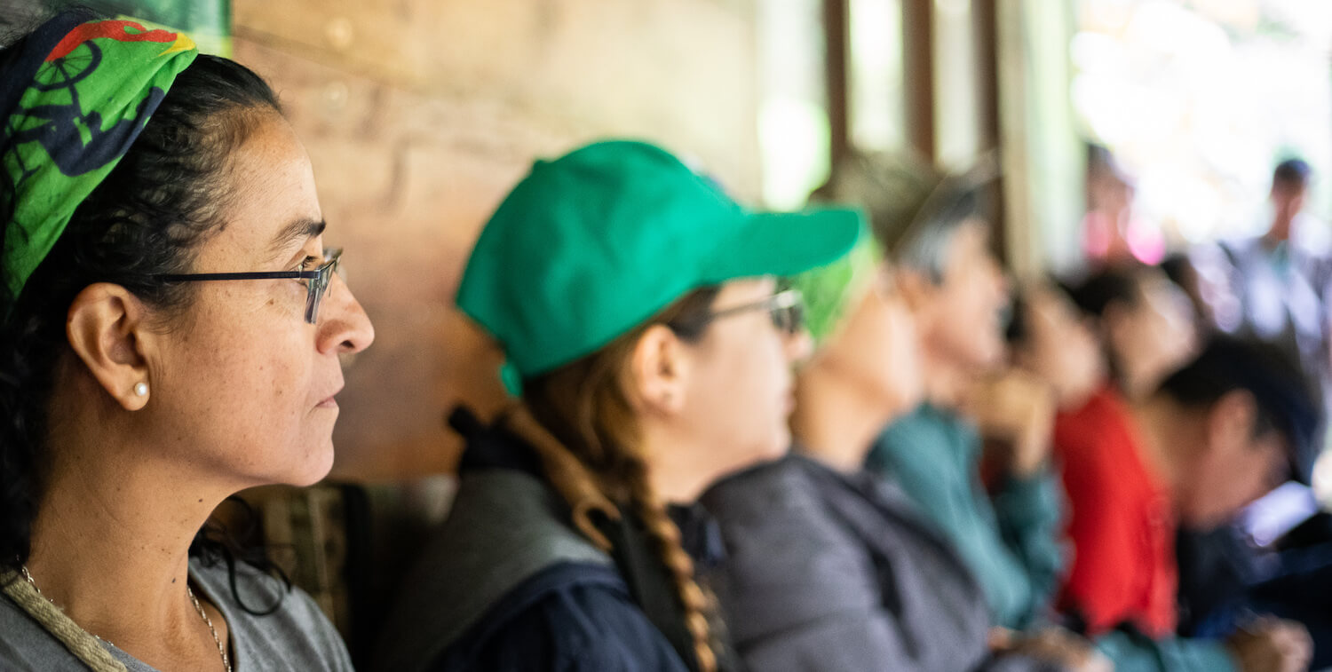 Close-up of people at meeting, looking to right.