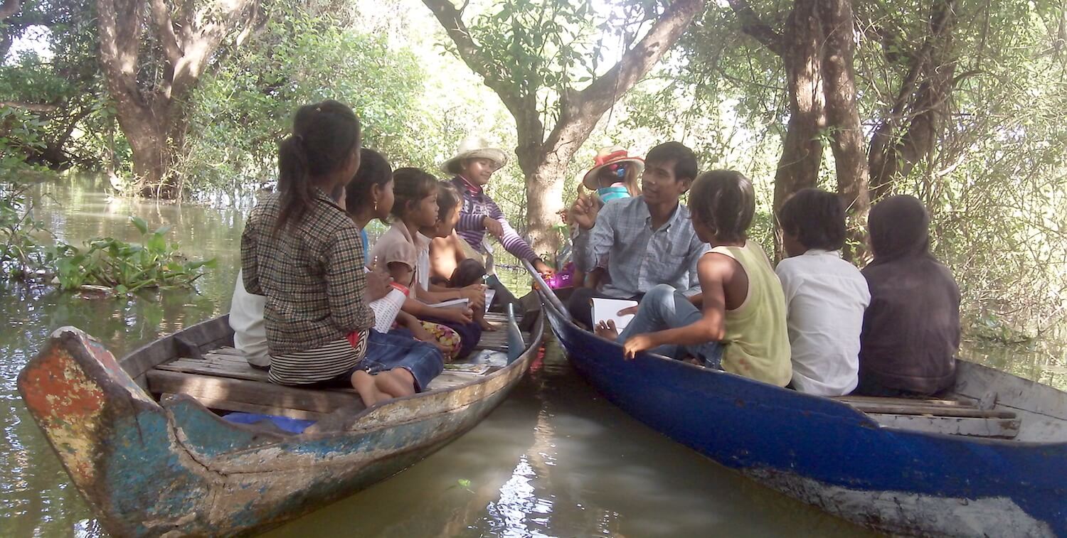 XNUMXつの木製のカヌーで子供と教師。
