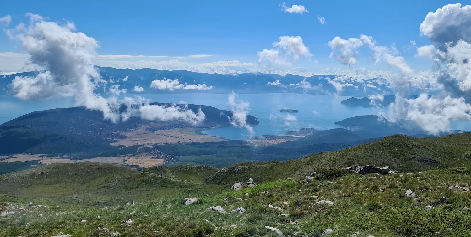 Vista with water in background and fluffy white clouds in the sky.