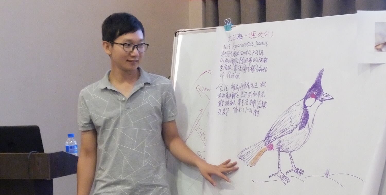 Joven mirando un cartel con dibujo de pájaro y escritura china.