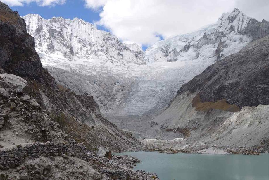 Lago glacial rodeado de montañas nevadas.