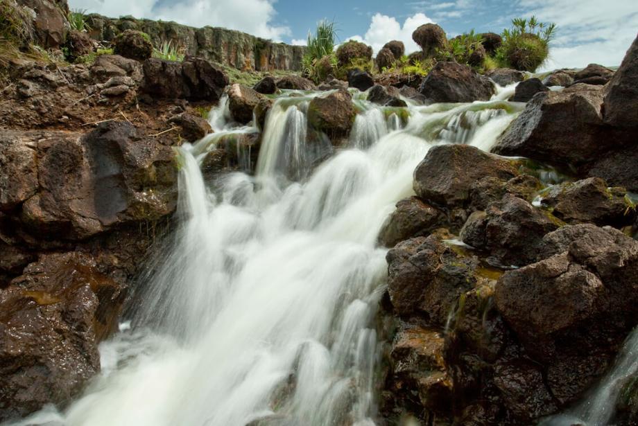 Cascada contra rocas marrones.