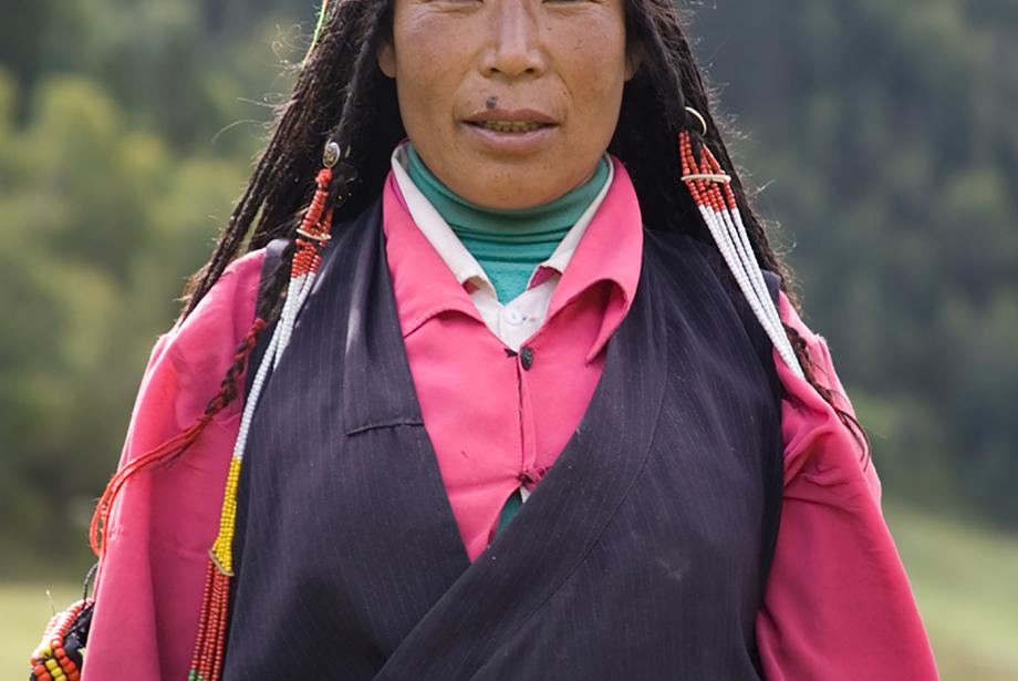Portrait of woman standing outside in traditional dress.