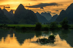 Collines reflétées dans l'eau au coucher du soleil.