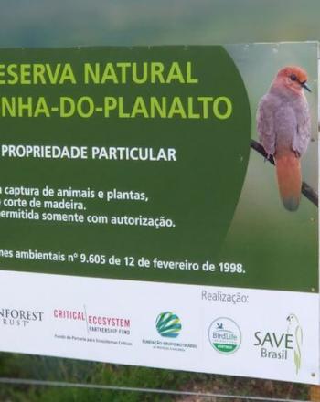 Sign for "Reserva Natural Rolinha-Do-Planalto with image of  blue-eyed ground-dove and list of funders, including CEPF, at the bottom.