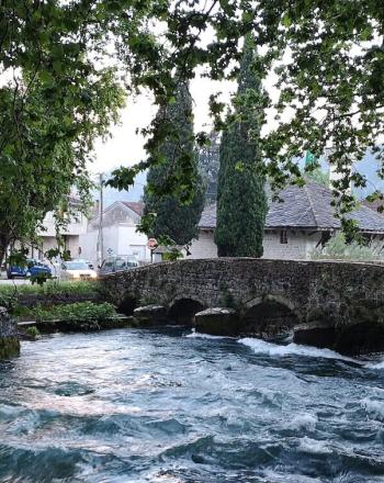 Río urbano con puente peatonal.