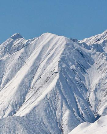 Close-up of snow-covered mountains ridgeline.