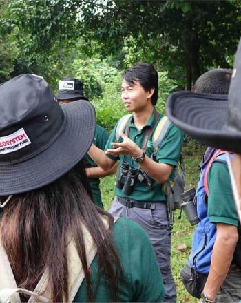 Small group wearing CEPF bucket hats standing outside around man giving instructions.