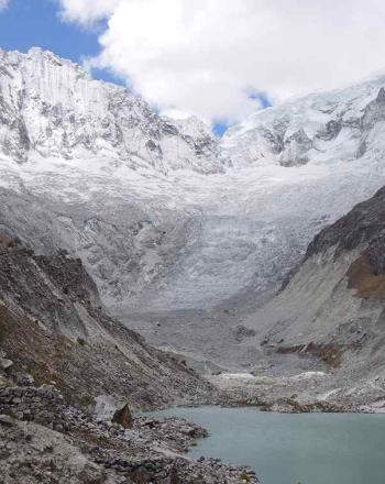 Lago glacial rodeado de montañas nevadas.