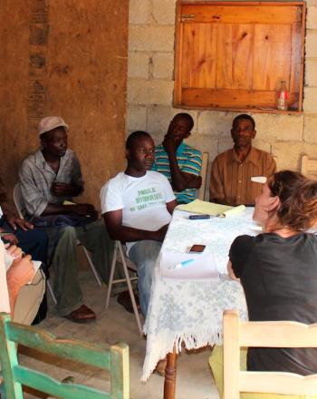 About a dozen people sitting around a table.