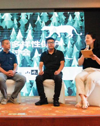 5 people sitting on stage, having discussion.