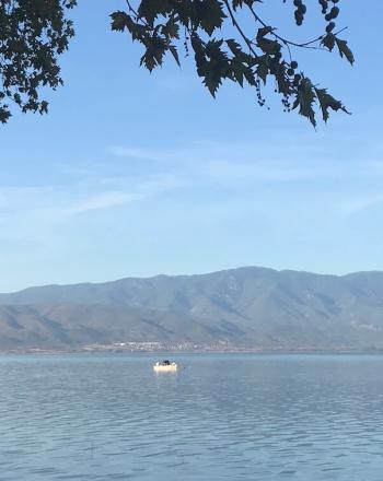 湖の眺望、遠くにXNUMX隻のボート、背景に山々