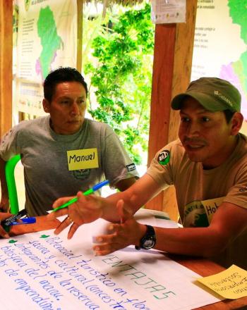 Group of four people at table in the middle of a discussion.