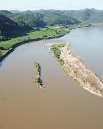 Vista aérea del río marrón con vegetación a ambos lados.