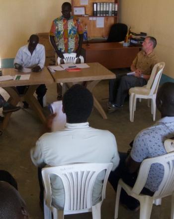 Handful of people, most seated, having discussion.