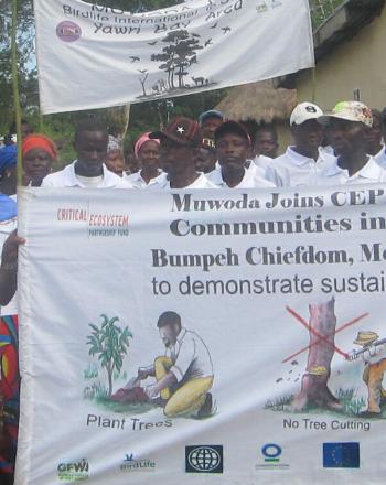 Group of people standing with large banner.
