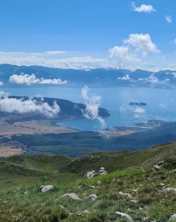 Vista with water in background and fluffy white clouds in the sky.