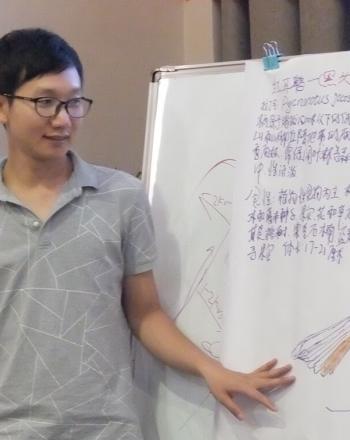 Young man looking at poster with bird drawing and Chinese writing.