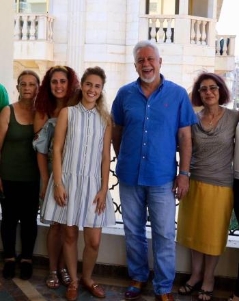 Group of 11 women and men standing, smiling at camera.