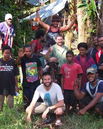 男性のグループは、パプアニューギニアのマヌス島の植生の多い地域でポーズをとります。