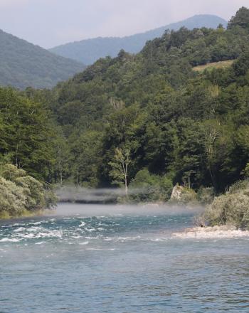 River, tree-covered hills on either side.