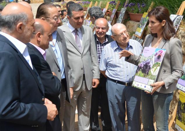 Afuera: Las mujeres sostienen un pequeño cartel con fotos de flores, hablan con unos 7 hombres.