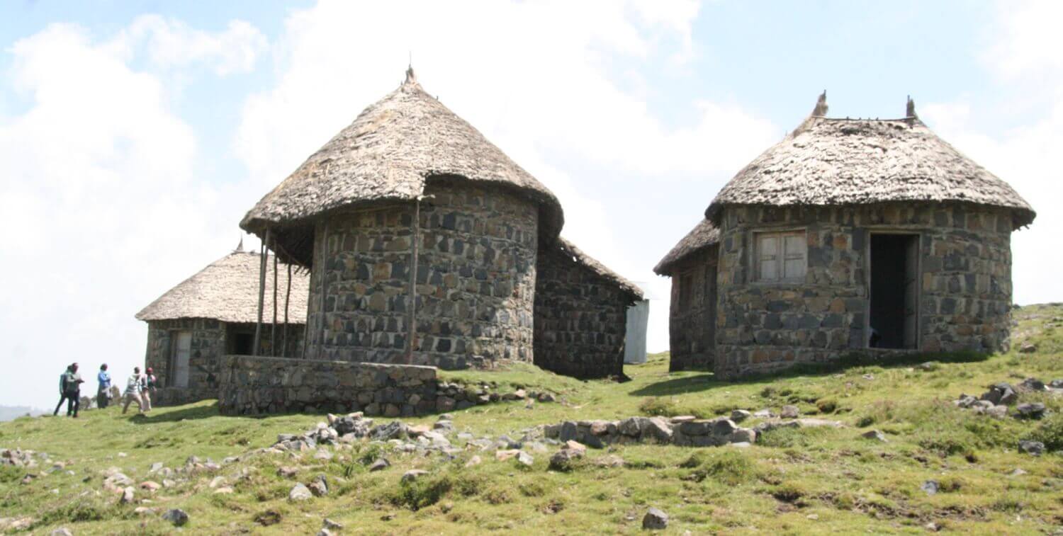 Round buildings with thatched roofs.